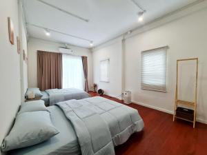 Bangkok NoiにあるWanglang Homeのベッド2台と鏡のある寝室