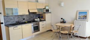 a small kitchen with a table and a small table with chairs at Villa gli Ulivi Chalten Apartment in Perledo +10 photos