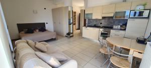a living room with a couch and a table and a kitchen at Villa gli Ulivi Chalten Apartment in Perledo