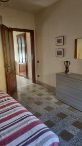 a bedroom with a bed and a dresser and a door at Casa Giardino in Barga