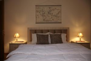 een slaapkamer met een wit bed met twee lampen bij Villa Berat - View of Berat Castle & Traditional Breakfast in Berat
