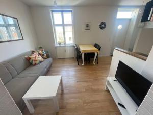 a living room with a couch and a table at Cozy base near the cathedral in Viborg