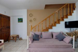 a living room with a couch and a staircase at BS Village green in Metamorfosi