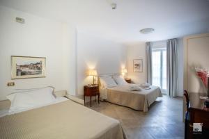 a hotel room with two beds and a window at Hotel Villa Elena in Varazze +118 photos