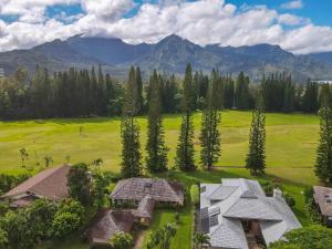 an aerial view of a house with mountains in the background at Hale Kamalani Mountain Villa and Golf Course Views in Princeville