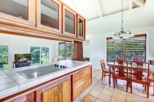 a kitchen with a table and a dining room at Hale Kamalani Mountain Villa and Golf Course Views in Princeville