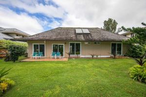 a house with blue chairs and a yard at Hale Kamalani Mountain Villa and Golf Course Views in Princeville