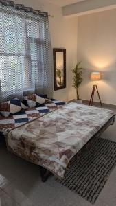 a large bed in a room with a couch at Nivaara in Bīr
