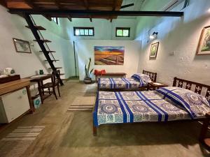 a bedroom with two beds and a table and chairs at Wilwatte Retreat in Mirigama