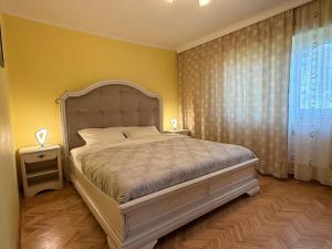 a bedroom with a large bed and a yellow wall at Apartment Palace of Parliament in Bucharest