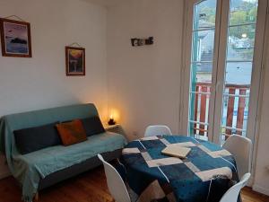 a living room with a table and a couch at T2 Coeur d' Argelès-Gazost, tout à pied in Argelès-Gazost