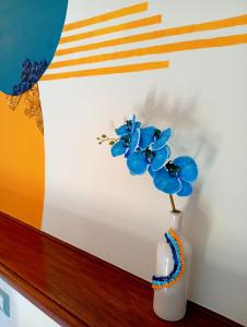 a white vase with blue flowers in it at I Mosaici Guesthouse in Ronco Scrivia