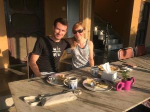 a man and woman sitting at a table with food at Hotel Sweetland in Sauraha