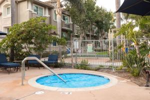 a small pool in a yard with chairs and an umbrella at Water Views on Every Floor for this multi Holiday Home - Walk to the Beach in Carlsbad