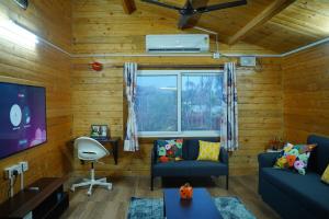 a living room with a couch and a window at Anagha, Wooden Cabin with Private Pool in Hyderabad