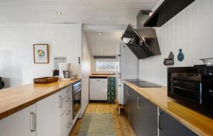 una cucina con mobili bianchi e un piano di lavoro in legno di Three-Bedroom Holiday Home In Strandby a Strandby
