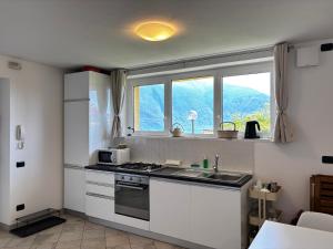 a kitchen with a sink and a stove top oven at Casa Karine Swimming Pool and Lake View - Larihome A43 in San Siro