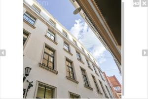 een groot wit gebouw met ramen aan een straat bij Old Town Quiet Rooftop Studio Apartment in Rīga