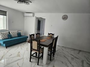 a dining room with a table and chairs and a couch at Casa Andreea in Corbu