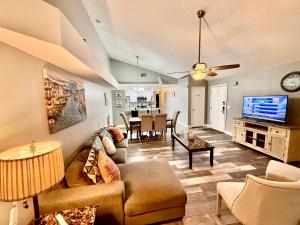 Una sala de estar con un sofá y un televisor. en Grand Laguna 3BR Penthouse Near Disney Parks, en Kissimmee