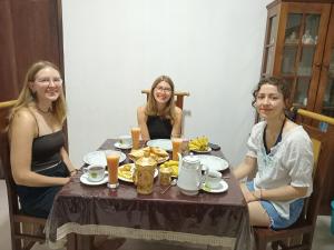 three women sitting at a table eating food at Kandy Horizon Homestay in Kandy