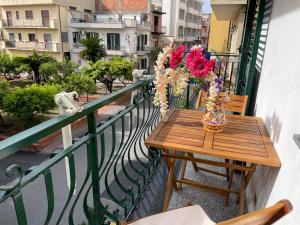 a table on a balcony with a vase of flowers at Il Glicine Apartment in Letojanni