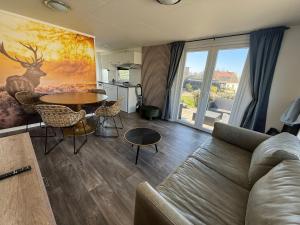 a living room with a couch and a table at Camping Wad noch Meer in Anna Paulowna +31 photos