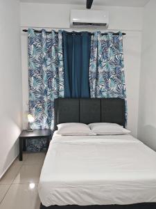 a bedroom with a large bed with blue and white curtains at V'saf Homestay Alor Setar in Alor Setar +72 photos