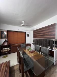 a dining room with a glass table and chairs at Surya's Serviced apartment in Kolhapur
