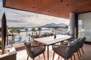 a dining room with a table and chairs and a view of the ocean at Luxury sea view Apartment in Puerto de Alcudia in Alcudia
