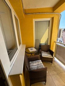 einen Balkon mit Stühlen und einem Tisch auf dem Balkon in der Unterkunft MATEA PREMIUM Apartment in Kragujevac