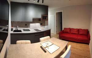 a kitchen and a living room with a red couch at AturCangas in Cangas de Onís