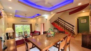 a dining room with a wooden table and a staircase at Casa Bella - 4BHK Arpora JAQK Holidays in Arpora