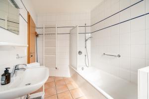 un bagno bianco con lavandino e doccia di Villa Hildegard Appartement 4 a Binz Altre 19 foto