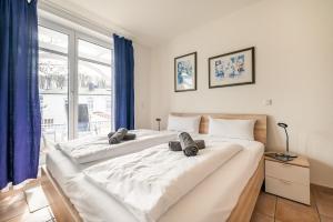 due grandi letti bianchi in una stanza con finestra di Villa Hildegard Appartement 4 a Binz