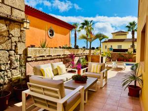 Un patio con sofás y una mesa y sillas. en Villa Chayofa, en Chayofa