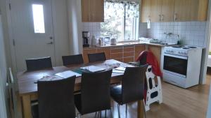 a kitchen with a wooden table with chairs and an oven at Brúnalaug Guesthouse - Holiday Home in Eyjafjaroarsveit