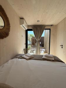 a large white bed in a room with a window at Exclusive Wellness House with Jacuzzi and Sauna, 10 Gardens in Privlaka