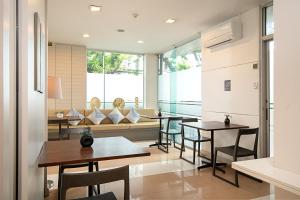 a dining room with tables and chairs and windows at Synsiri Ladprao 130 in Ban Bang Toei (1)