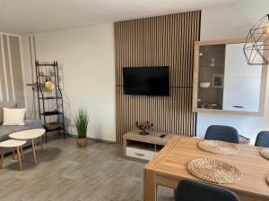 a living room with a television and a table and chairs at Ferienwohnung Leopold in Tschernitz
