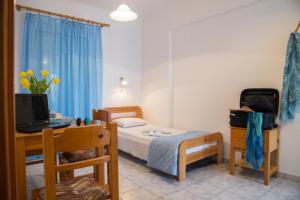 a bedroom with a bed and a desk with a computer at Yiannis Yard studios & apartments in Kos Town