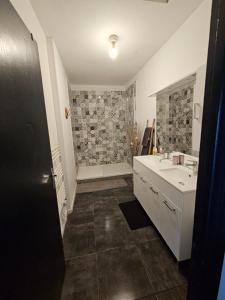 Un baño con lavabo blanco y ducha. en Gîte des Cyprès, en La Garde-Adhémar