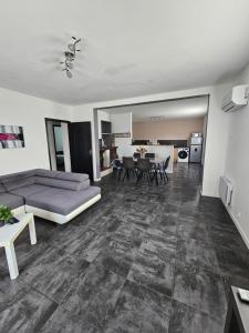 una sala de estar con un sofá y una mesa en Gîte des Cyprès, en La Garde-Adhémar