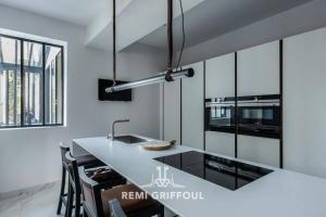 una cucina con pareti bianche e bancone con lavandino di Villa Gernez Historic Center 10 guests a Honfleur