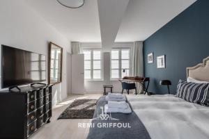 una camera da letto con un letto grande e una televisione di Villa Gernez Historic Center 10 guests a Honfleur