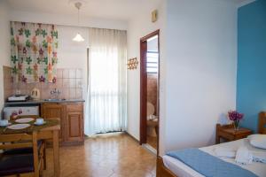 ein Schlafzimmer mit einem Bett und einem Tisch sowie eine Küche in der Unterkunft Yiannis Yard studios & apartments in Kos-Stadt