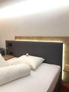 2 camas con almohadas blancas en una habitación en Sonnenhotel Soldanella Sonneck, en Samnaun