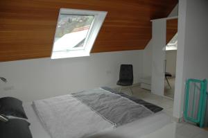 a bedroom with a bed with a window and a chair at Ferienwohnung Sylvianne in Ottenhöfen