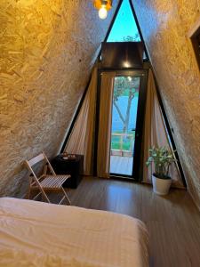 a attic bedroom with a bed and a window at Guest House Adilaj in Berat