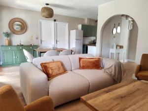 a living room with a couch and a kitchen at La Gigotière, 5mn du ZooParc de Beauval in Noyers-sur-Cher +12 photos
